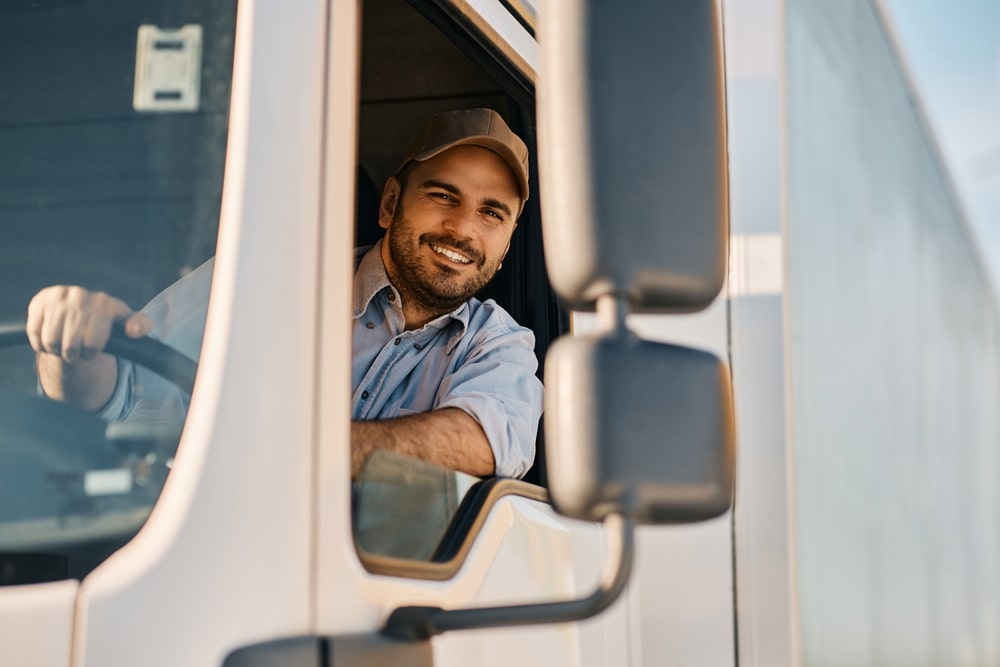 Truck Driver Looking Out Of The Window And Smiling