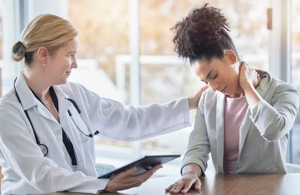 Woman Holding Her Neck In Pain At The Doctors Office
