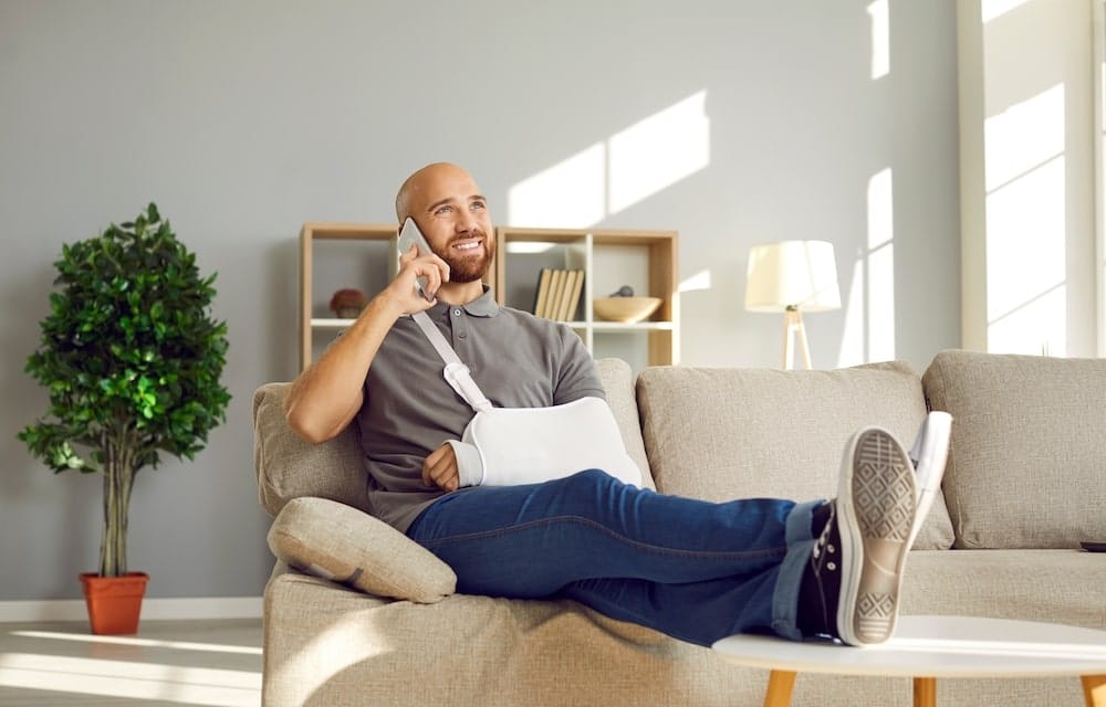 Man With A Broken Arm Talking On The Phone And Smiling