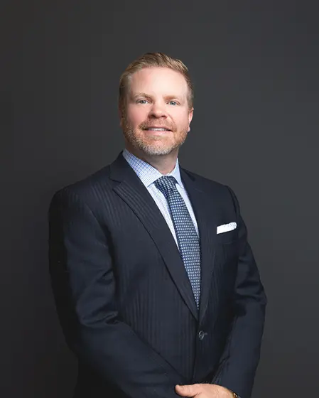 Professional headshot of Wesley Burton, man wearing navy pinstripe suit with blue patterned tie.