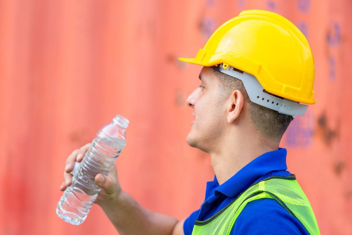 Close up of Worker man in hard hat drinking water at containers cargo